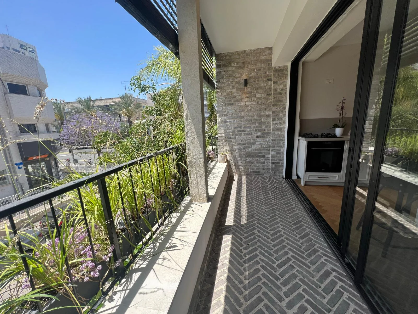 Terrasse ensoleillée avec vue sur la rue arborée