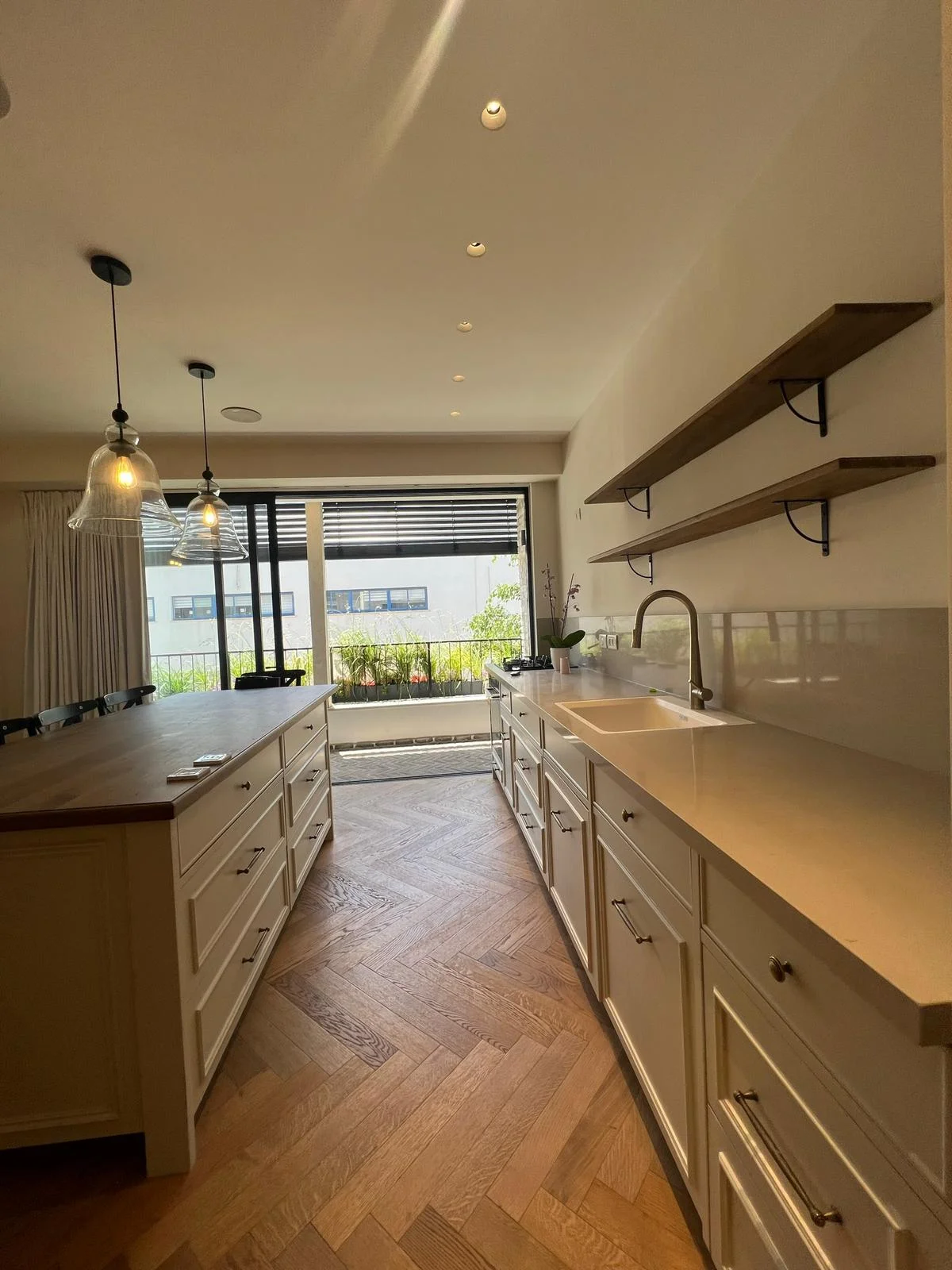 Cuisine sur mesure avec parquet à chevrons et îlot central