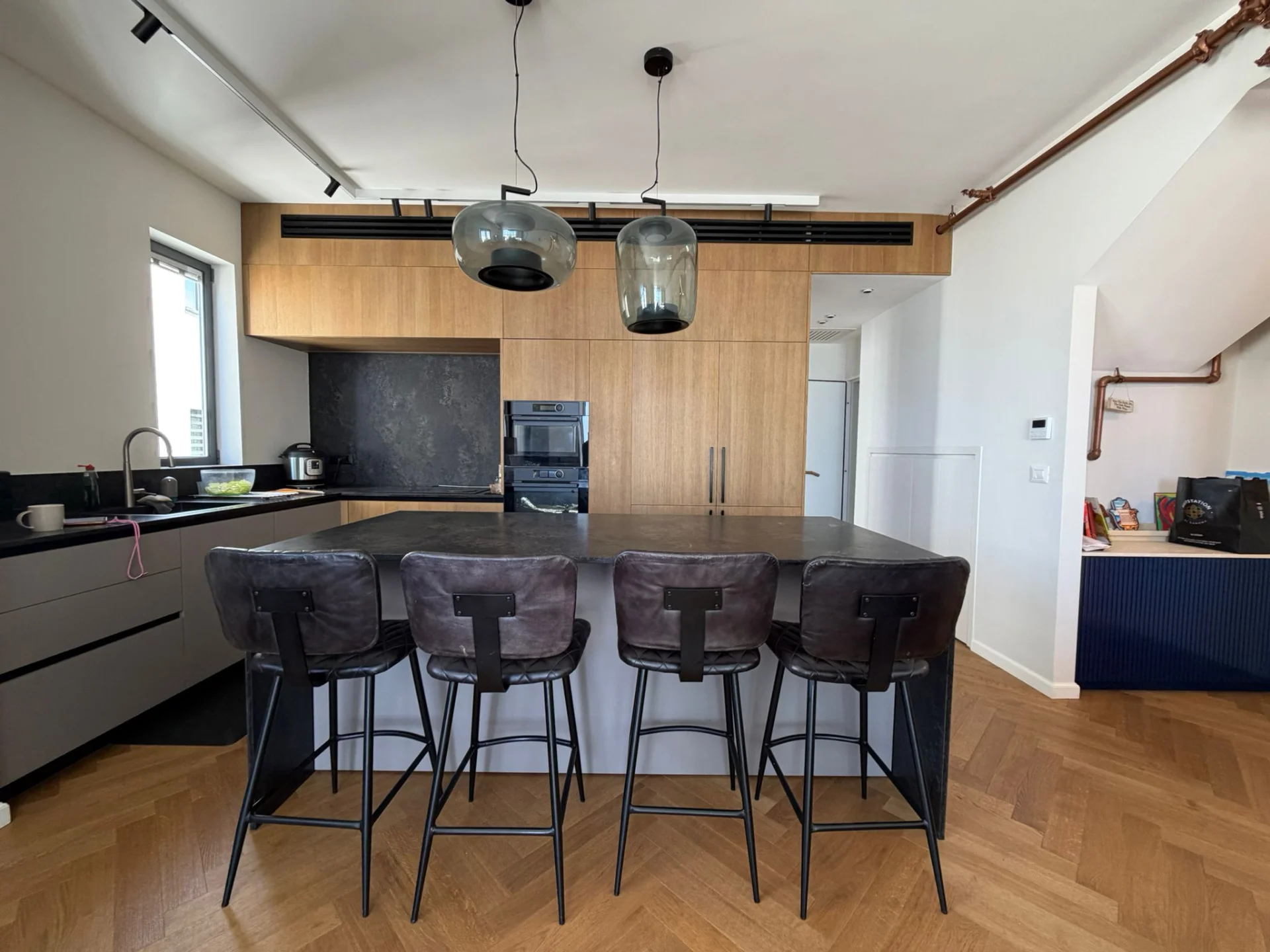 Cuisine design avec îlot central et tabourets en cuir