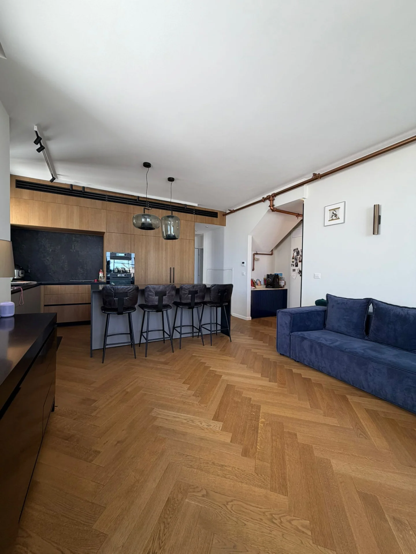 Séjour et cuisine ouverts avec parquet en chevron