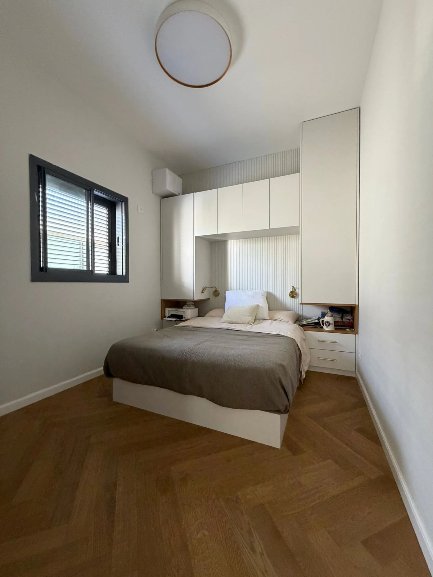 Chambre avec rangements intégrés et parquet en chevron