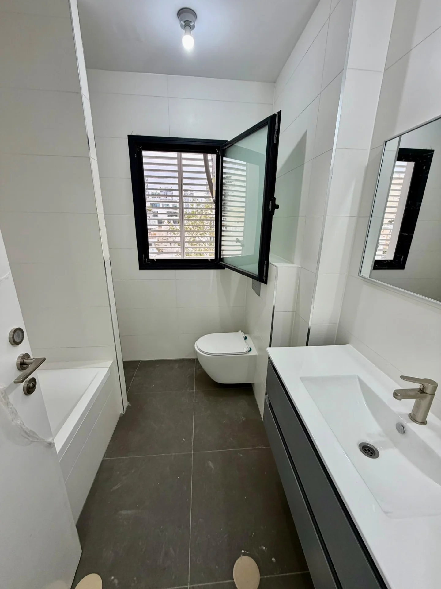 Salle de bain avec baignoire, lavabo et fenêtre