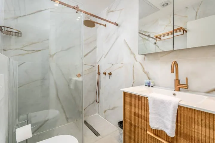 Salle de bain en marbre blanc avec robinetterie dorée