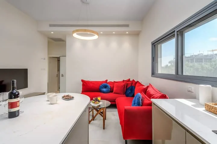 Salon ouvert sur la cuisine avec canapé rouge