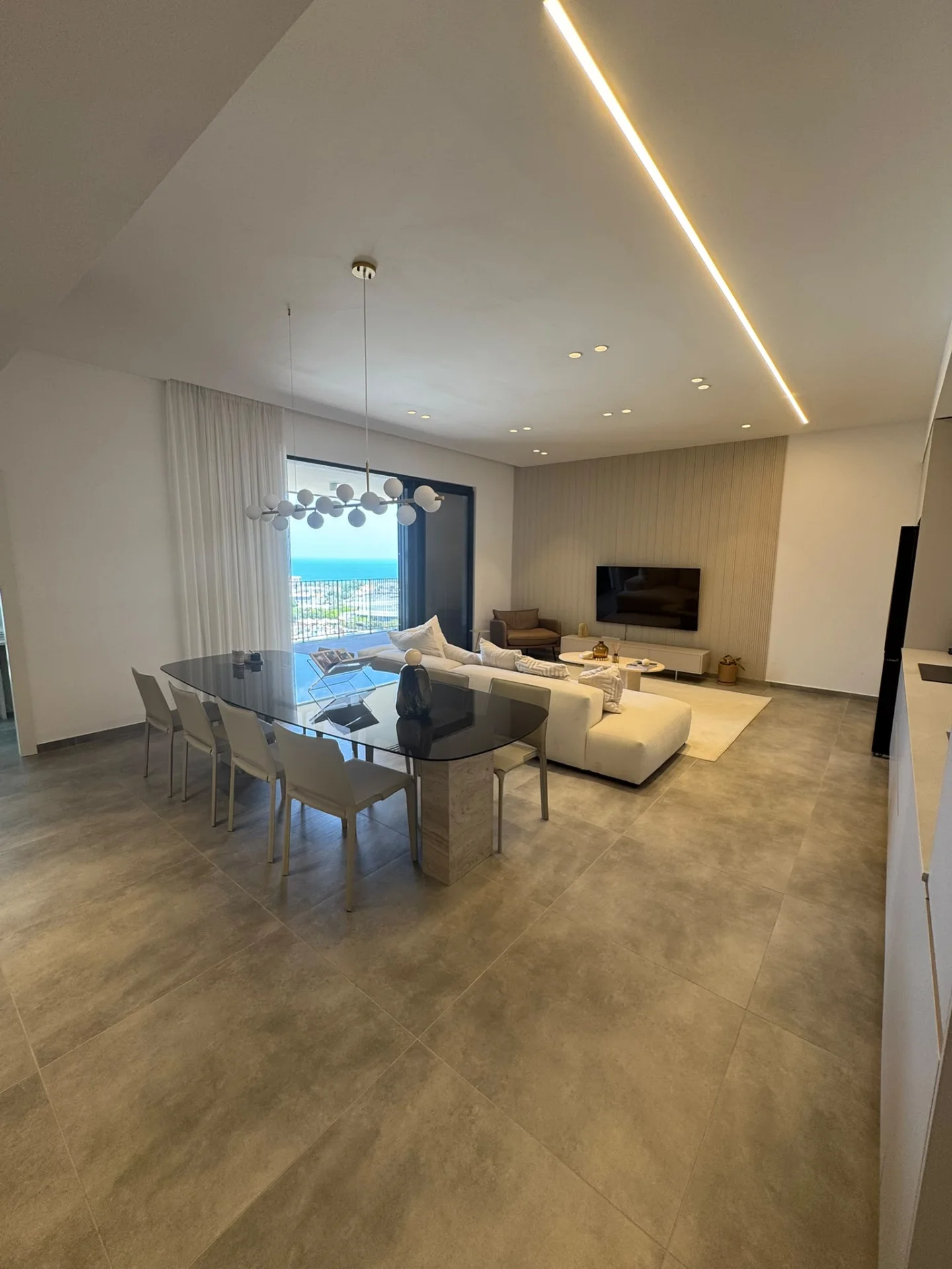 Salon et salle à manger avec vue mer et lustre design
