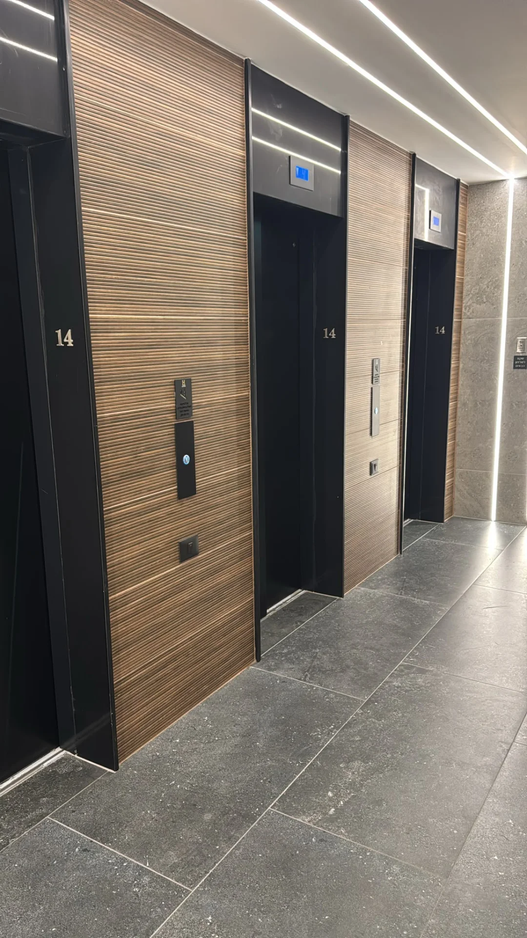 Couloir des ascenseurs avec finitions bois et pierre