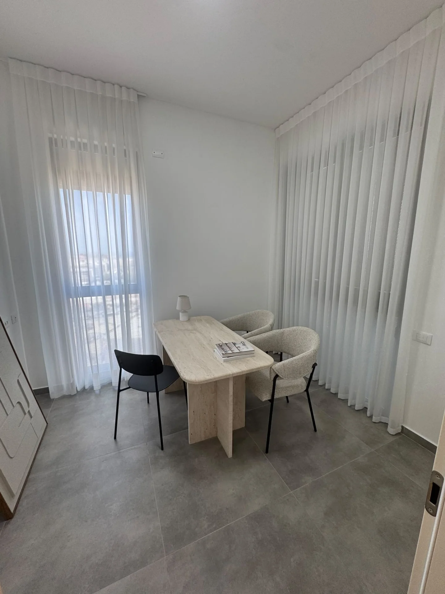 Bureau lumineux avec rideaux blancs et table en travertin