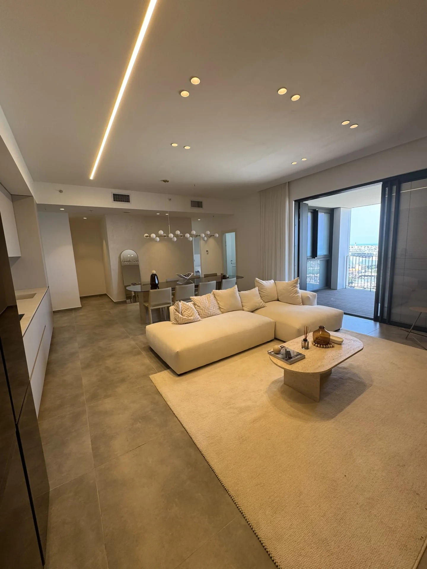 Salon lumineux avec éclairage indirect et accès à la terrasse