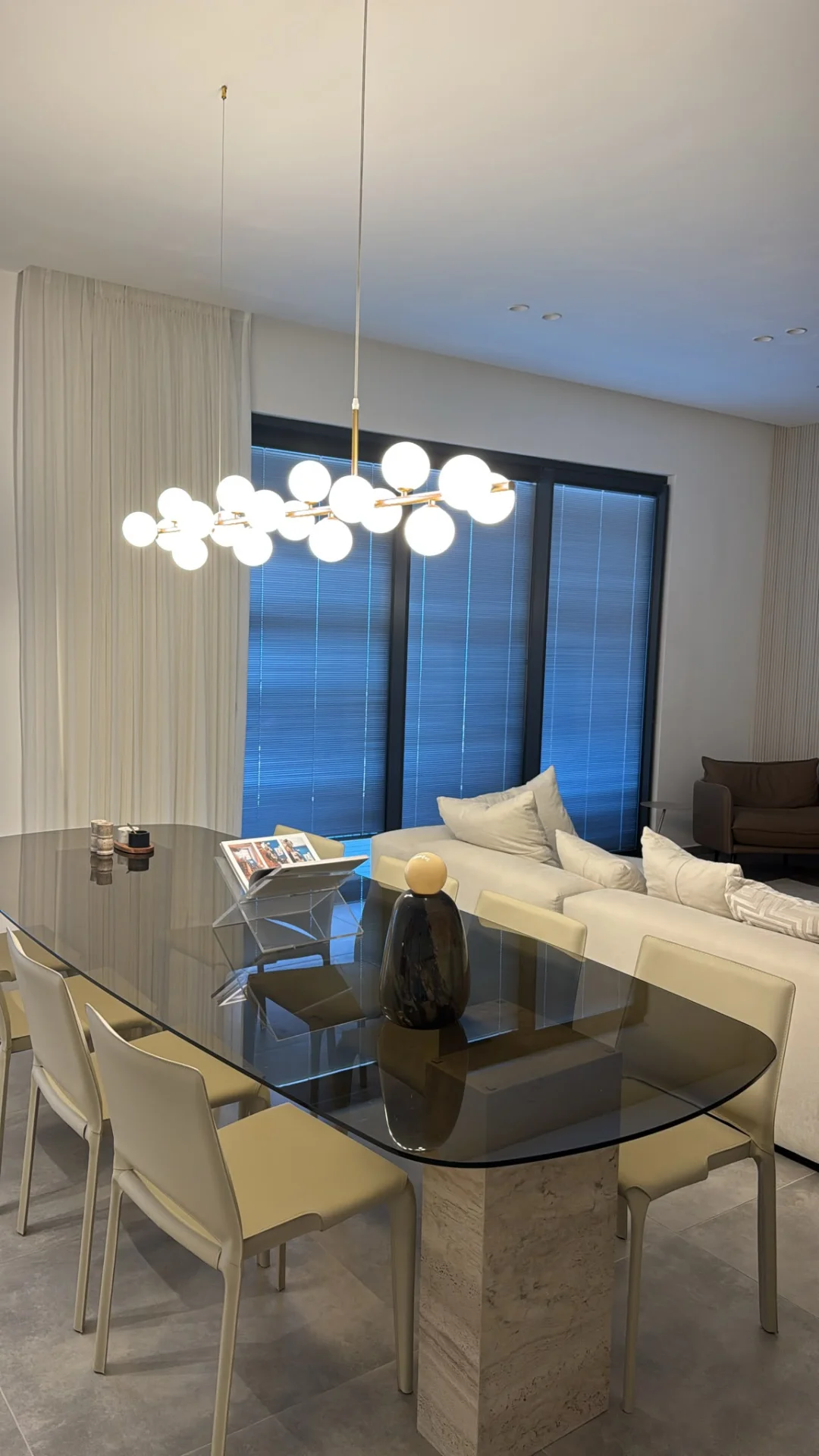 Salle à manger avec table en verre et éclairage élégant