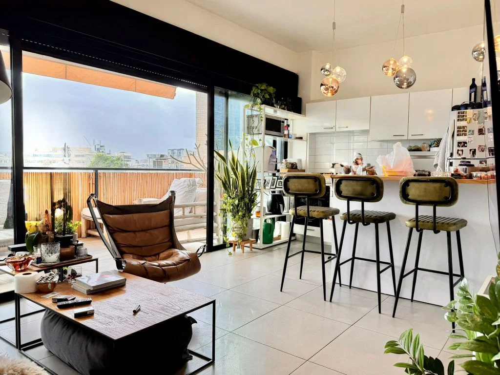 Séjour ouvert sur la terrasse avec îlot bar et suspensions design