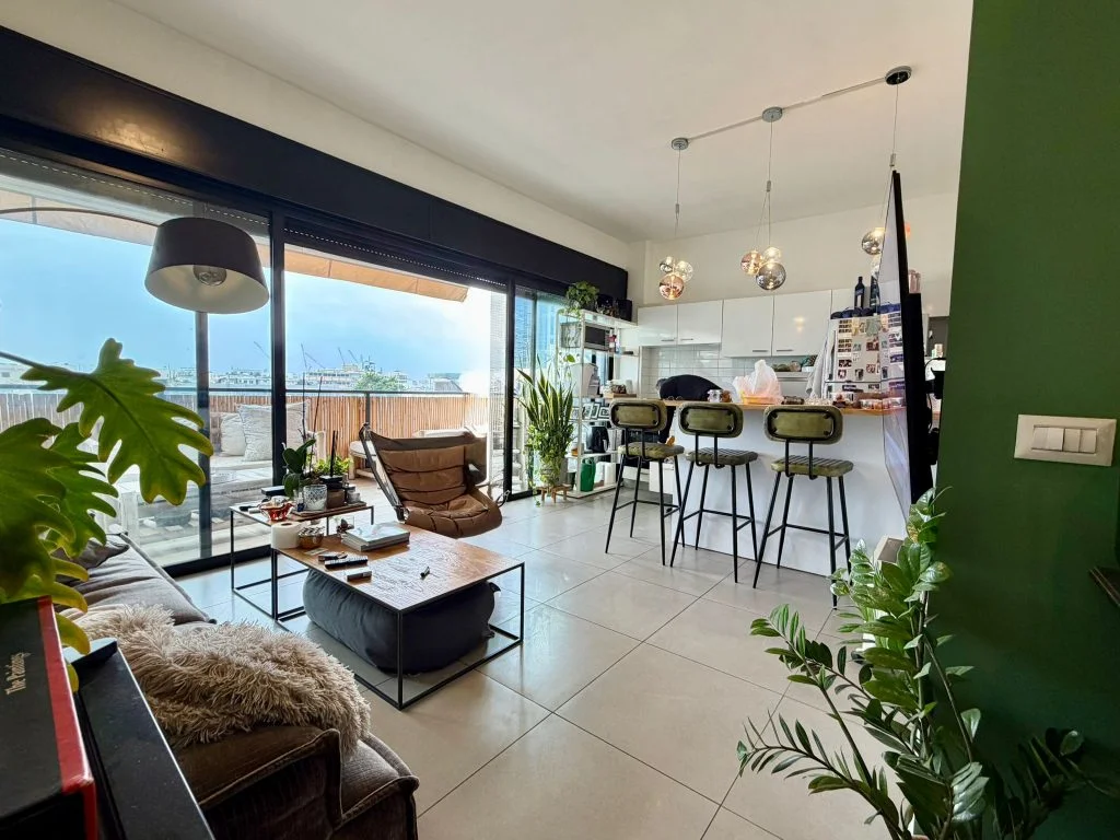 Salon avec fauteuil en cuir et vue dégagée sur la terrasse