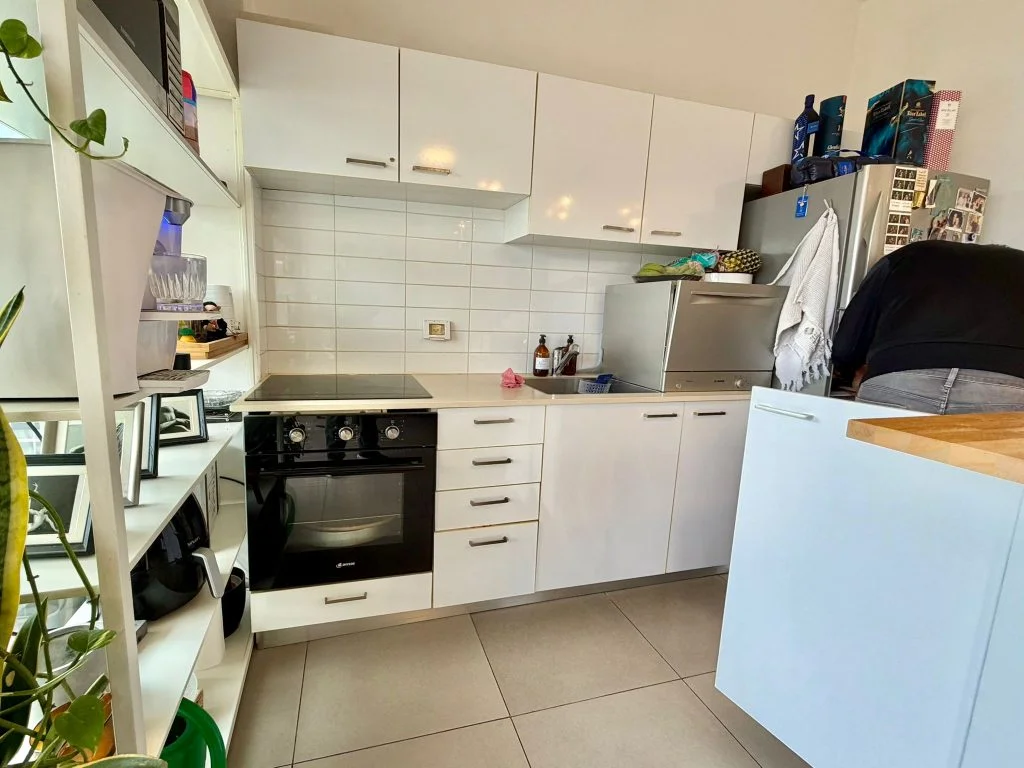 Cuisine équipée blanche avec plan de travail et four encastré