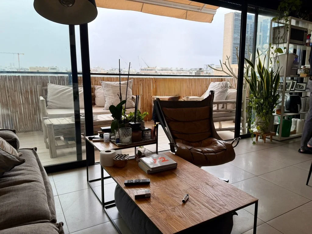 Salon avec fauteuil en cuir et vue panoramique sur la ville