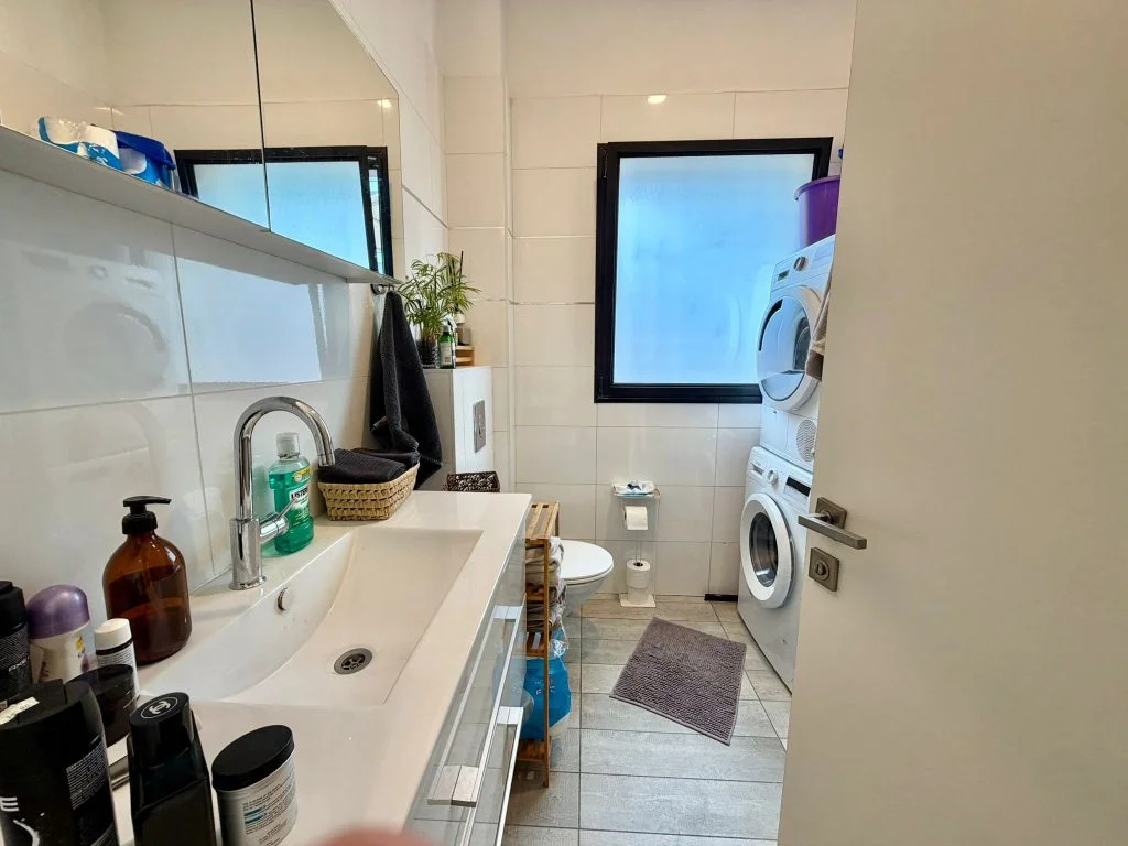Salle de bain avec double vasque et lave-linge