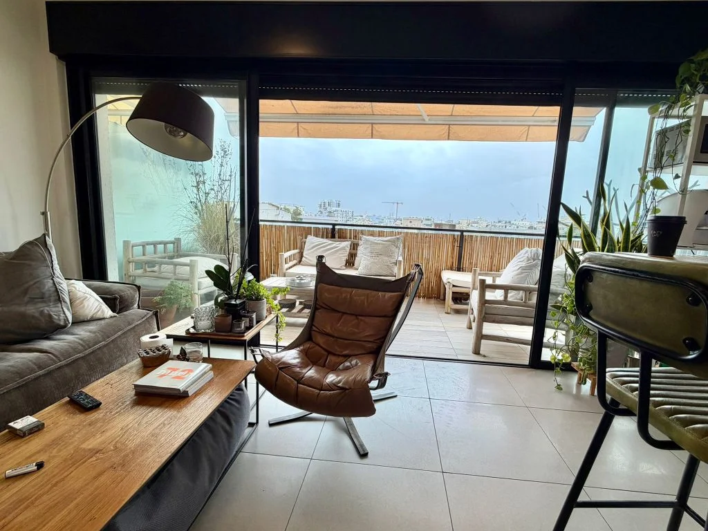 Salon baigné de lumière naturelle avec accès à la terrasse