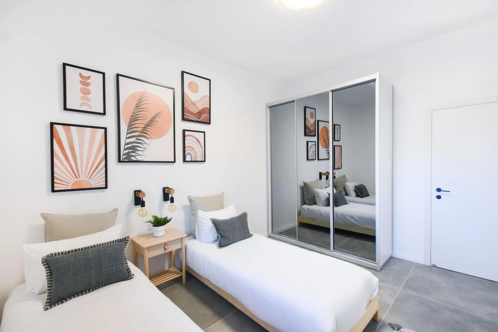 Chambre avec lits simples et armoire miroir