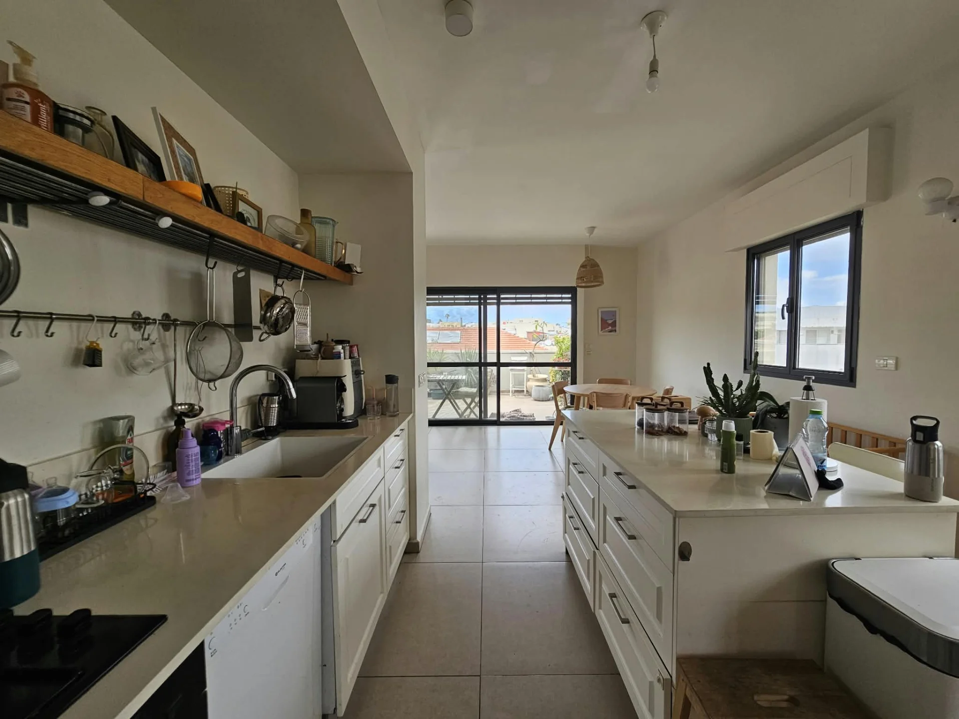Cuisine ouverte avec îlot central et vue sur le balcon