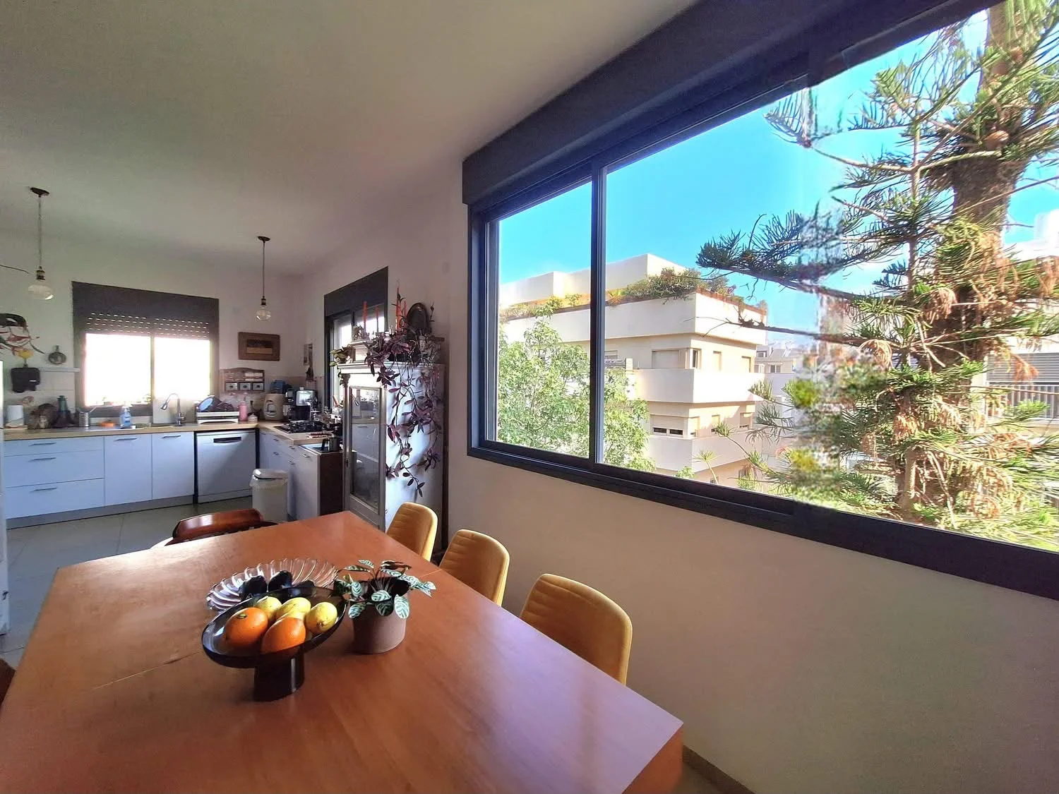 Espace repas et cuisine baignés de lumière naturelle