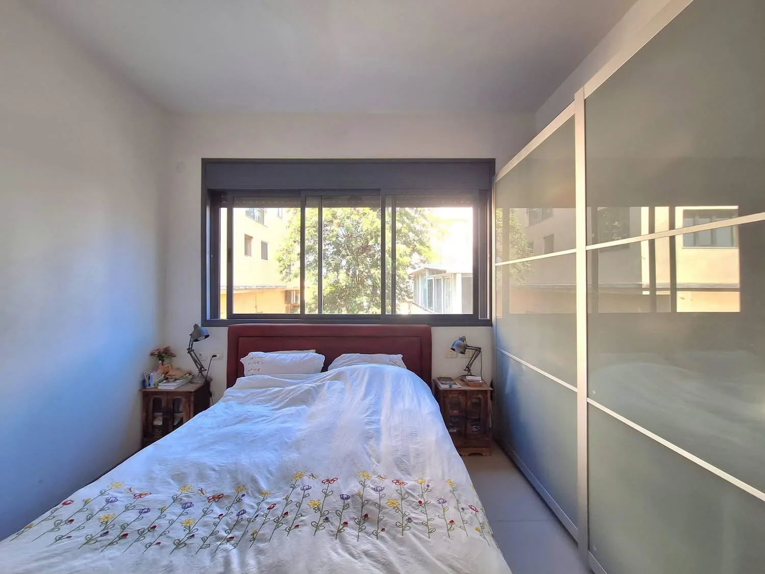Chambre parentale avec placards coulissants et vue sur les arbres