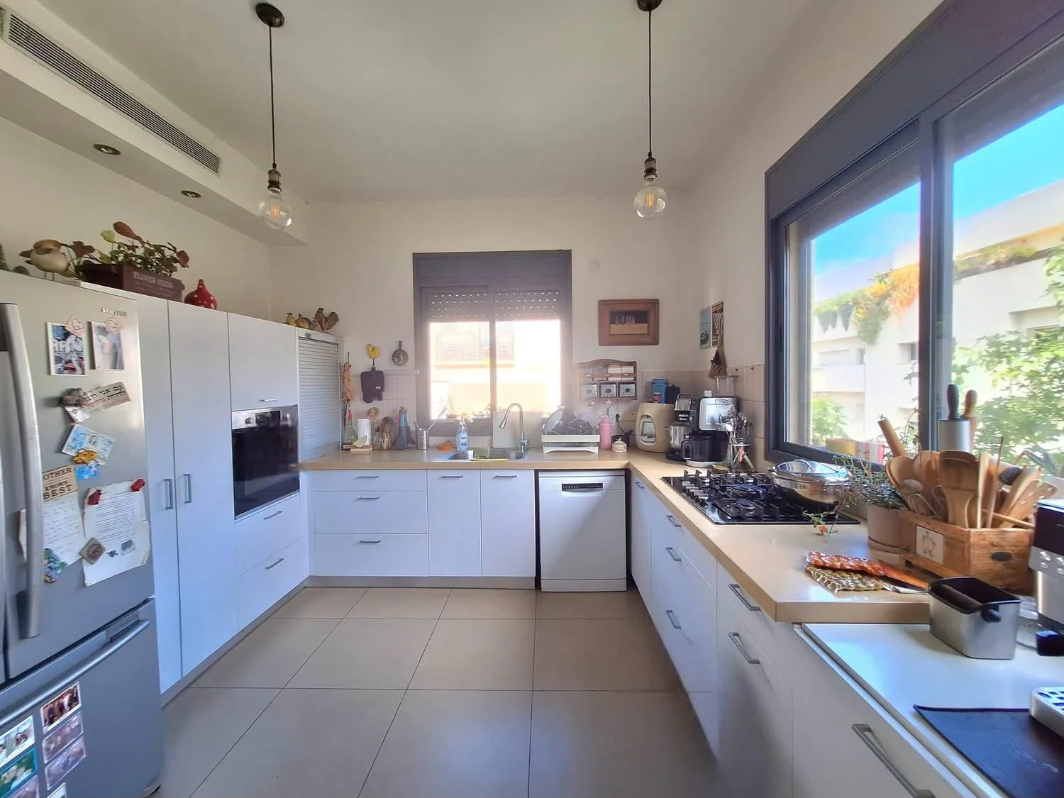 Cuisine spacieuse équipée avec double fenêtre et climatisation