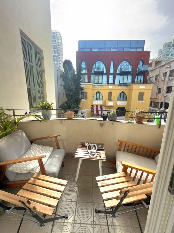 Terrasse avec salon de jardin en bois et vue sur la ville