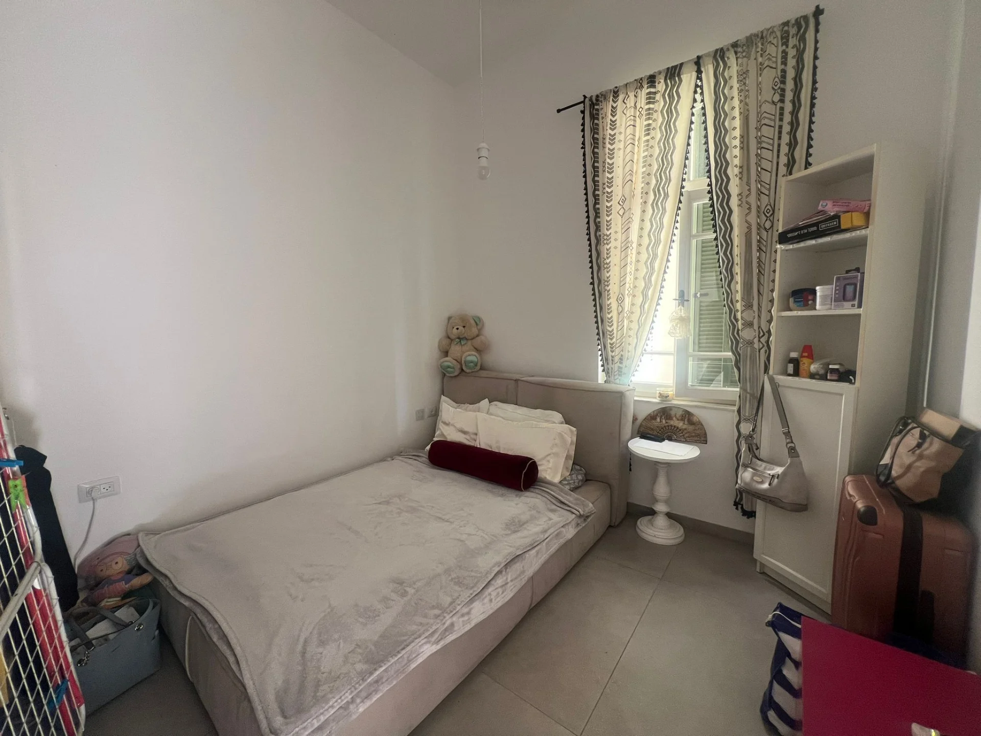 Deuxième chambre avec fenêtre et rideaux ethniques