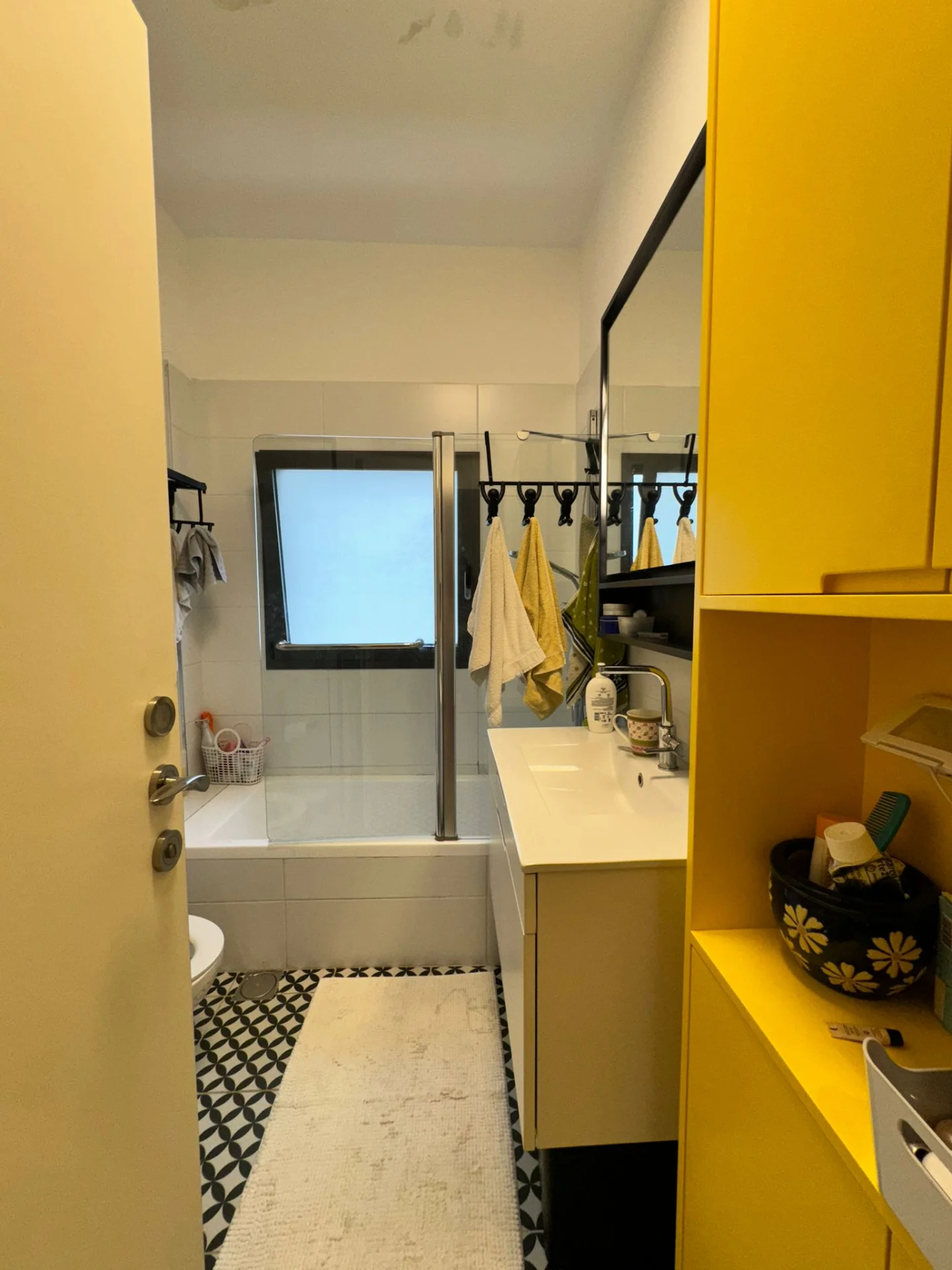 Salle de bain avec baignoire et meubles jaunes