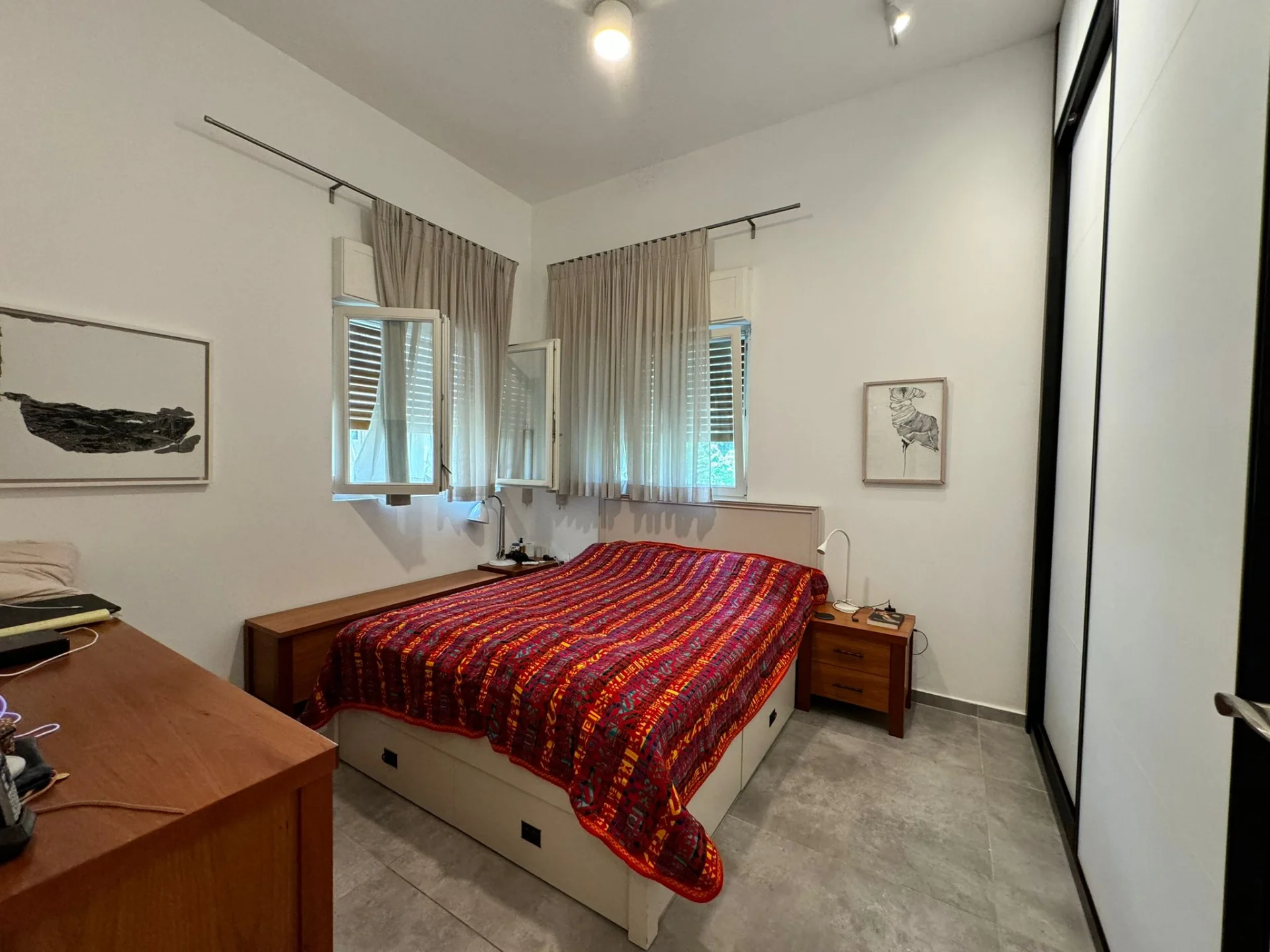 Chambre avec lit double et fenêtres avec volets