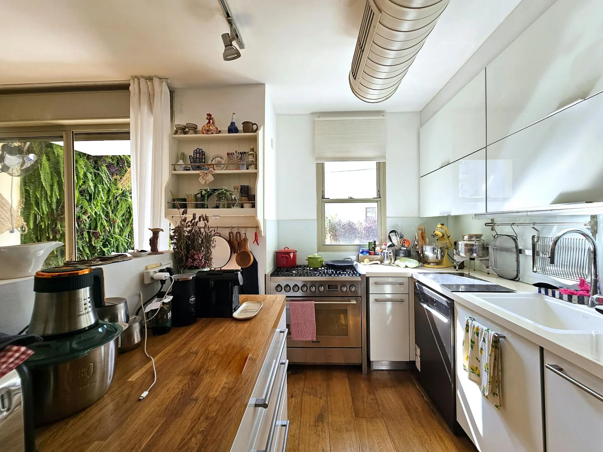 Cuisine équipée avec îlot central et accès jardin