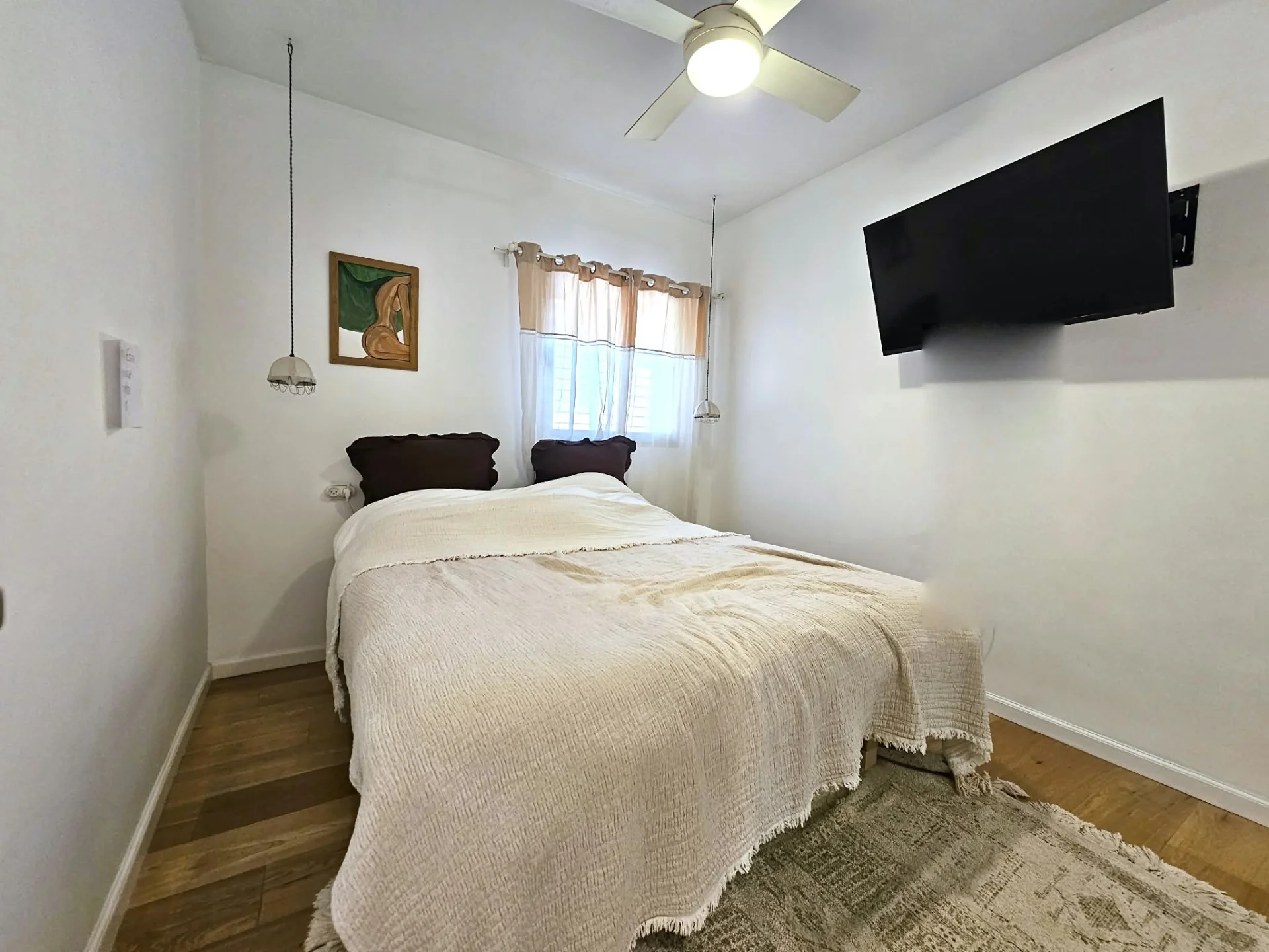 Chambre avec parquet et ventilateur de plafond