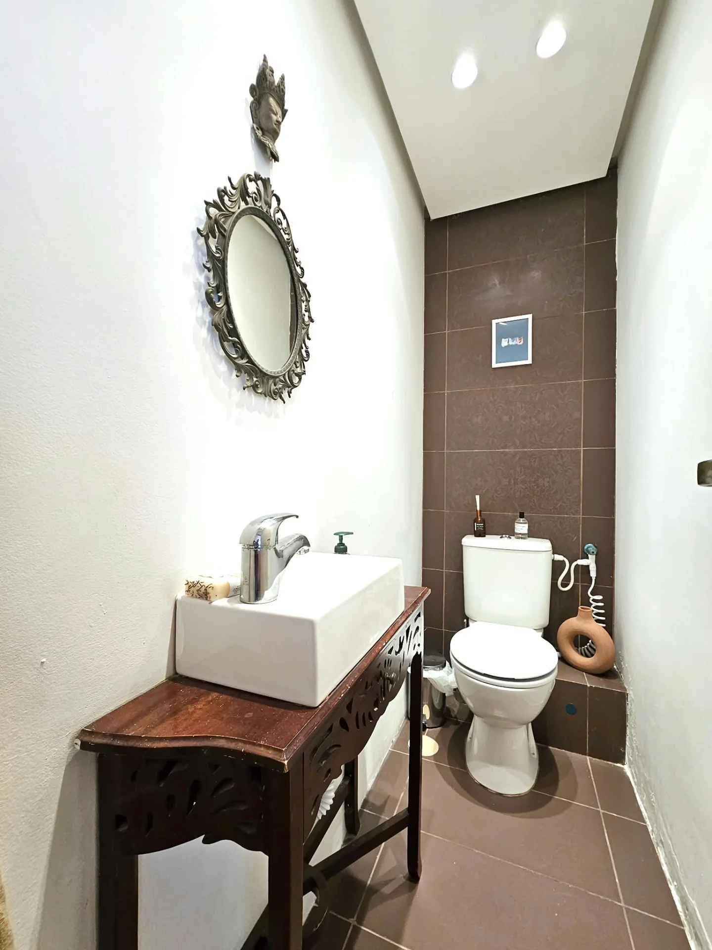 WC avec vasque sur meuble en bois sculpté et miroir baroque