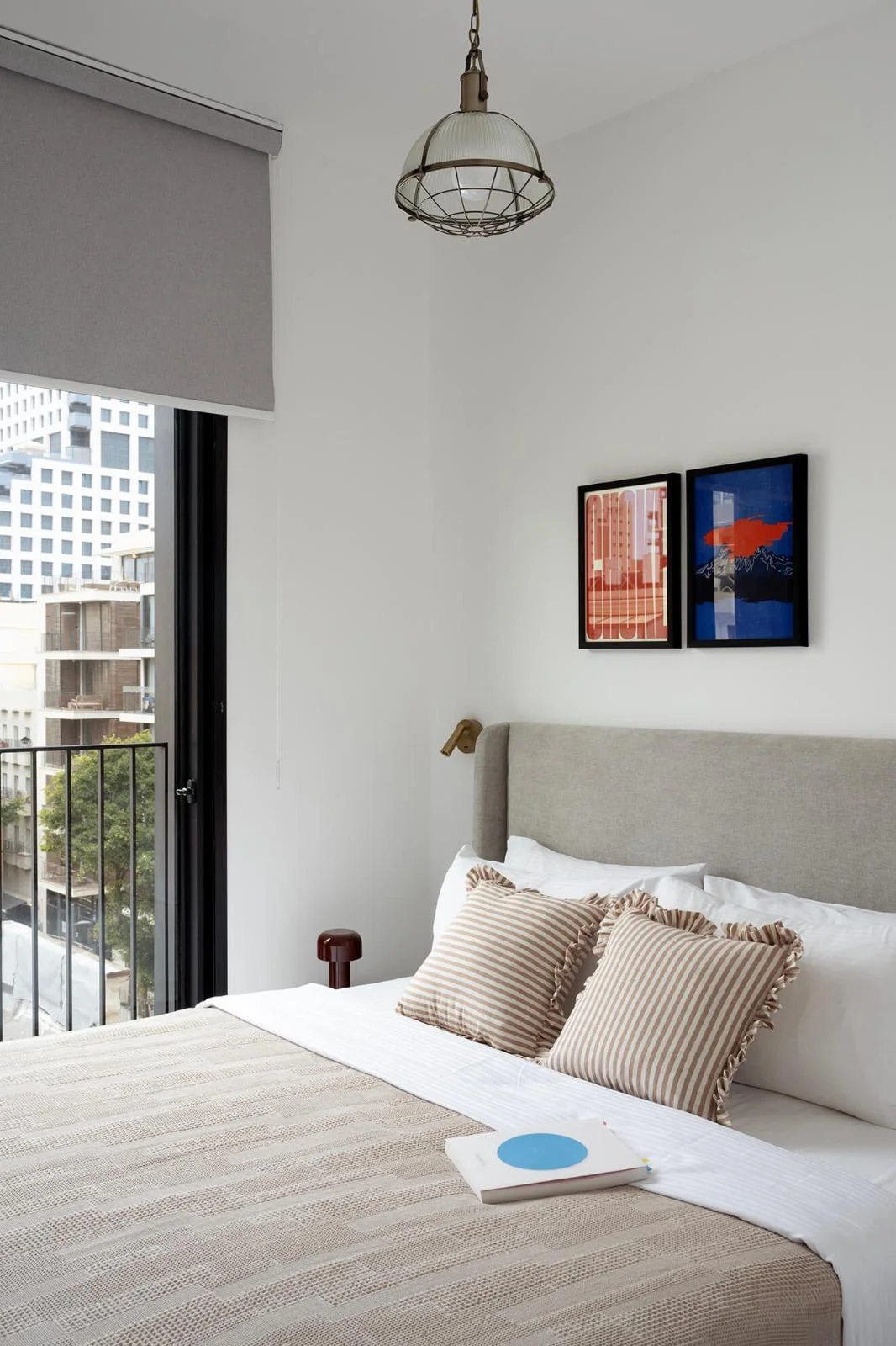 Chambre avec tête de lit tapissée et œuvres d'art