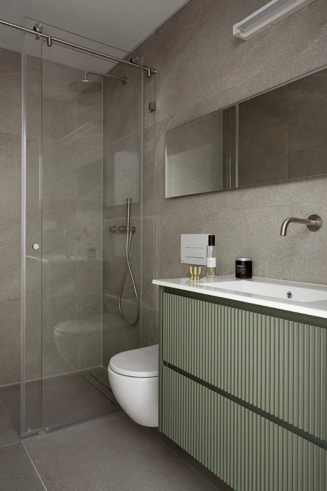 Salle de bain avec douche en verre et meuble vert