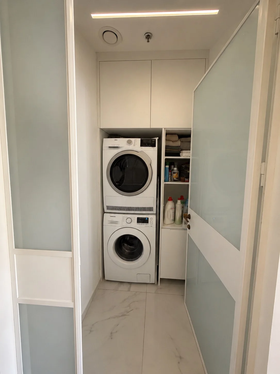Local buanderie avec lave-linge et sèche-linge superposés
