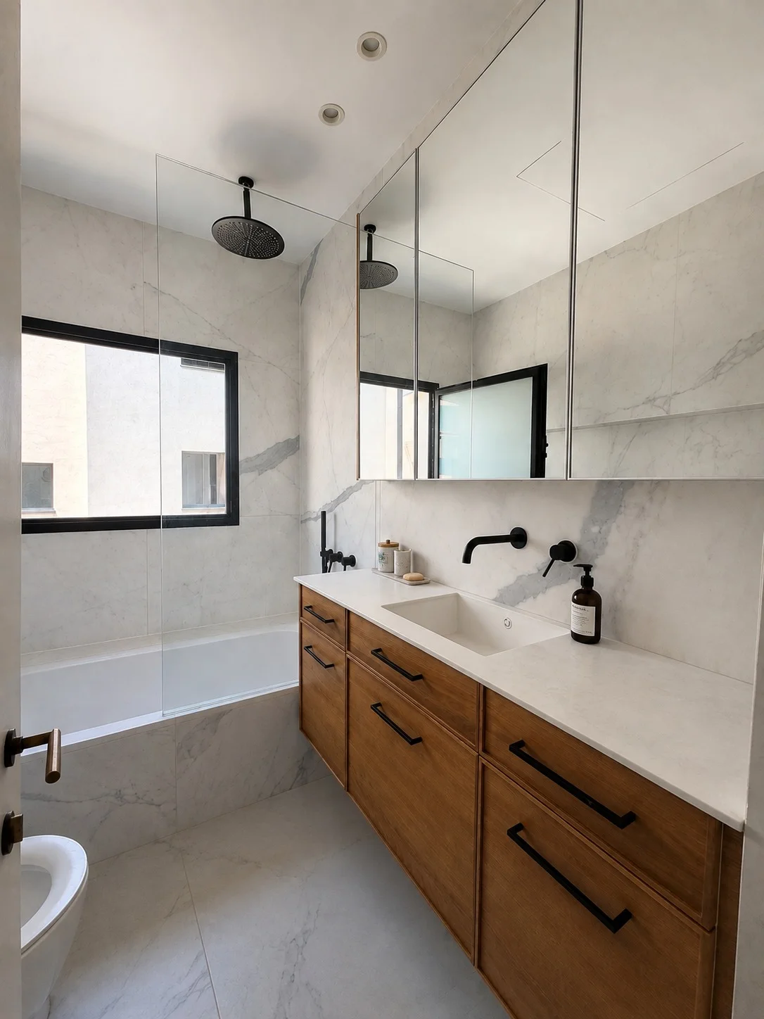 Salle de bains avec baignoire, carrelage marbre et robinetterie noire