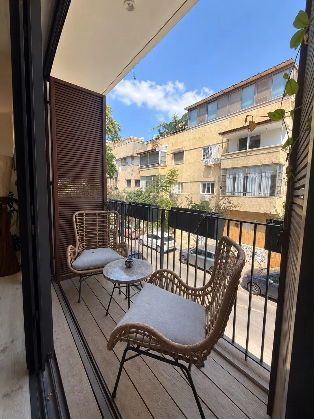 Balcon avec mobilier en rotin et vue sur la rue