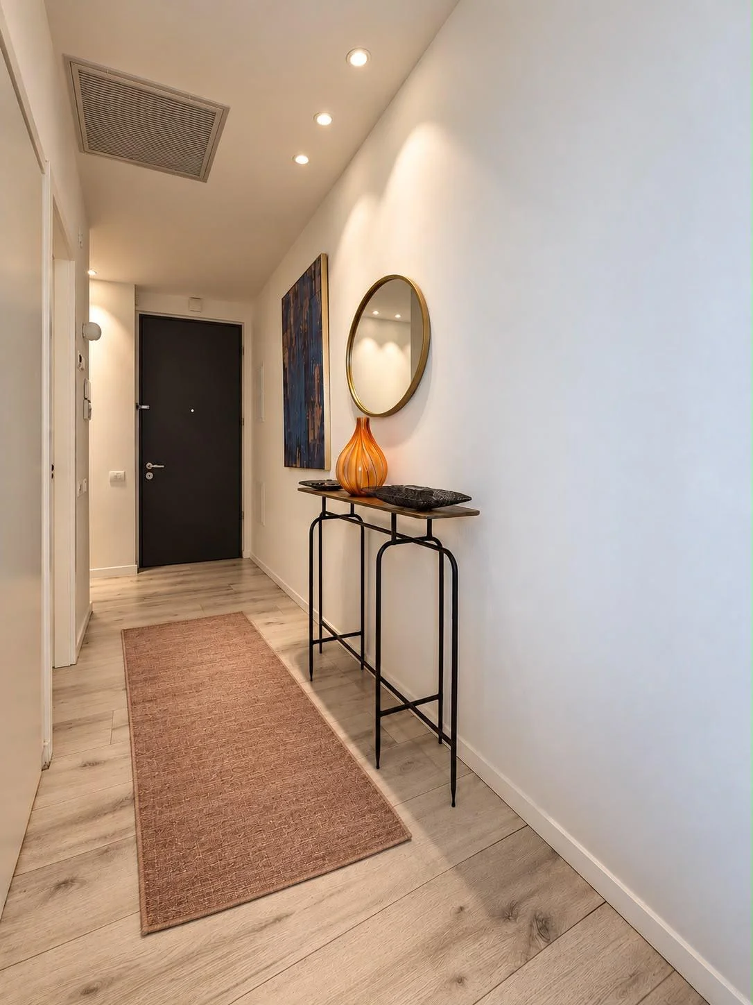 Couloir d'entrée avec console décorative et miroir rond