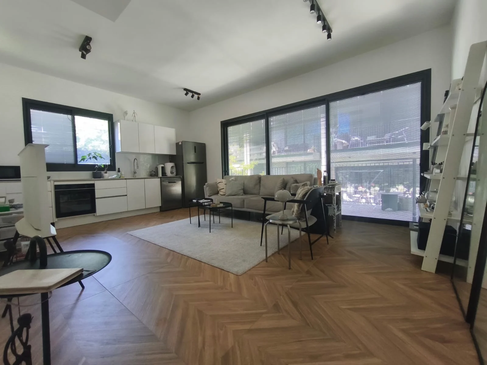 Séjour ouvert avec cuisine équipée et parquet en chevron