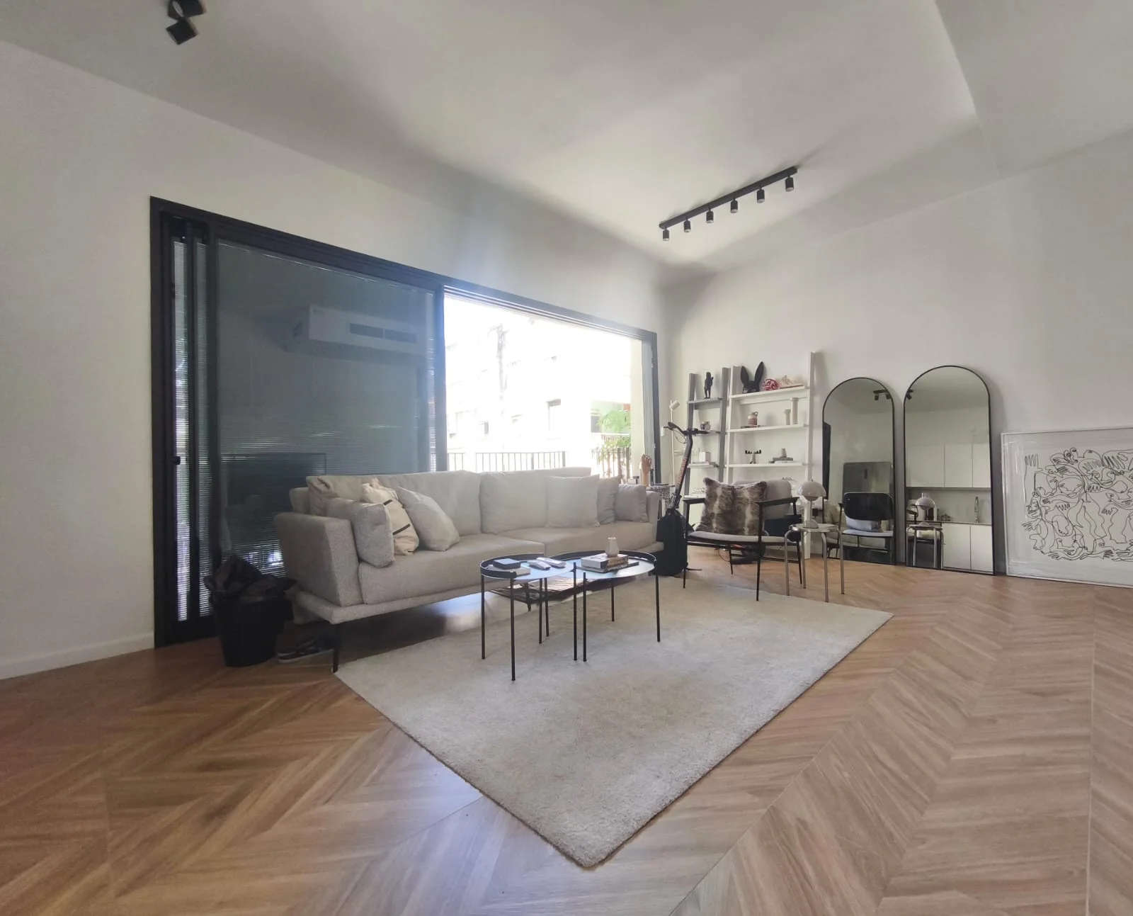 Salon lumineux avec grandes baies vitrées et parquet en chevron
