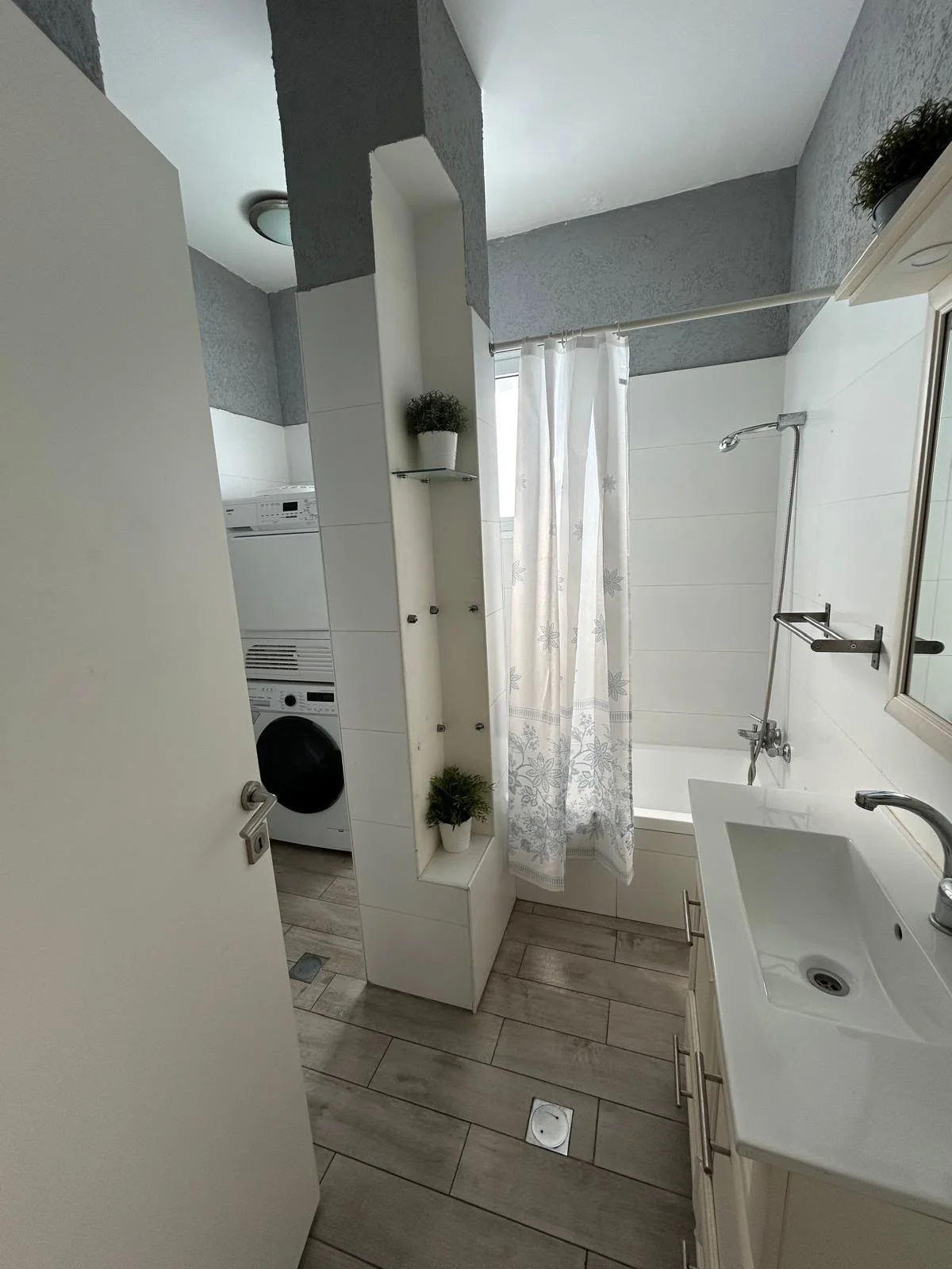 Salle de bain avec baignoire et lave-linge